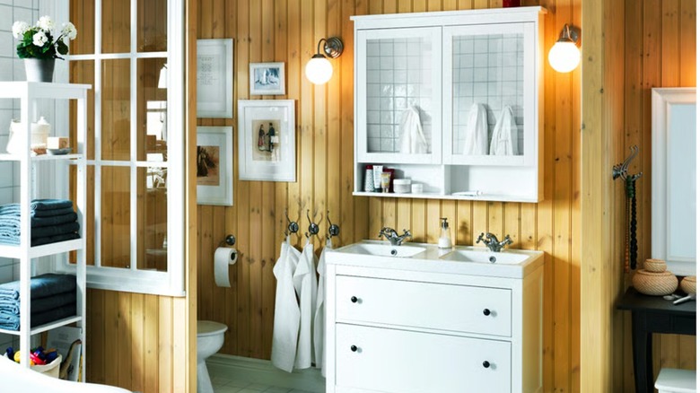 A white dresser and mirrored cabinet in a rustic bathroom