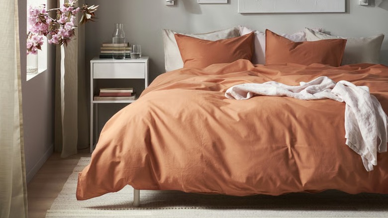A red-brown duvet with matching pillows on a bed