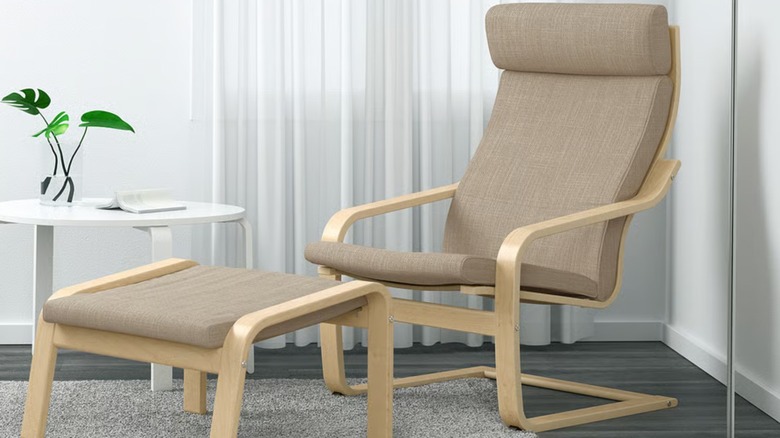 A beige and wood armchair with a matching stool in front