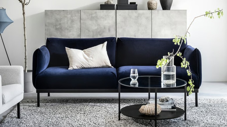 A dark blue loveseat in a living room