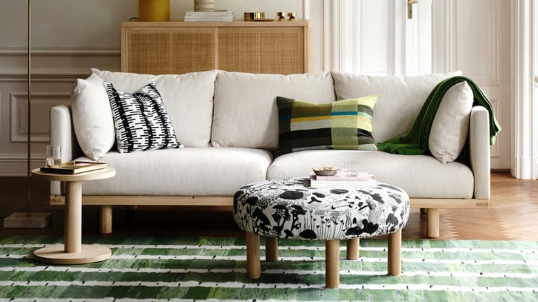 A spacious beige sofa in a living room with designer cushions on top