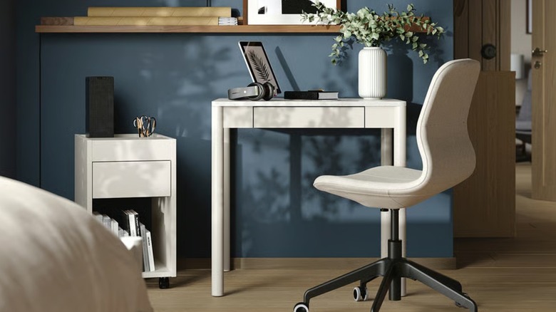 A white desk, chair, and side table in a small home office