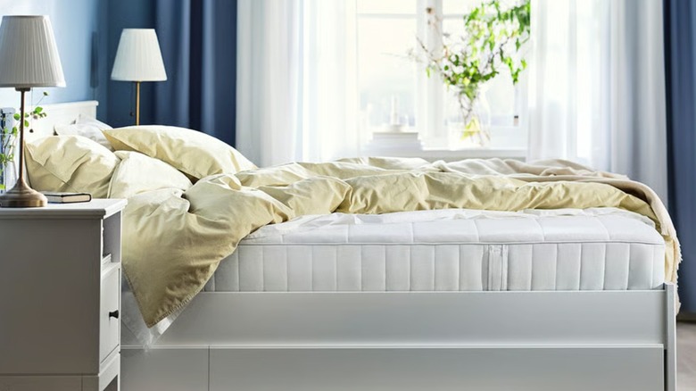 A cushy, white mattress on a white bed frame