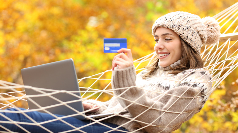A person shopping online with a background of fall foliage