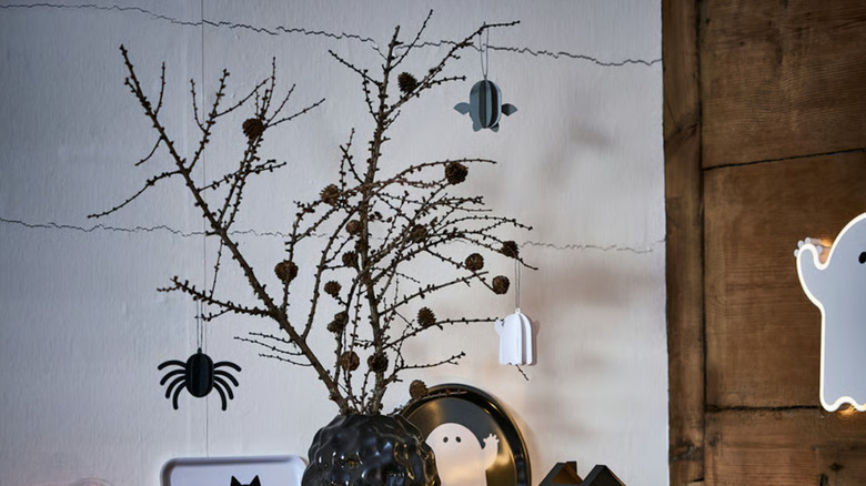 A spooky black Halloween tree with small seasonal ornaments including a vampire, spider, and ghost