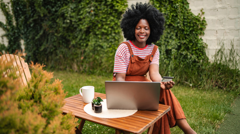 A person shopping online in the backyard