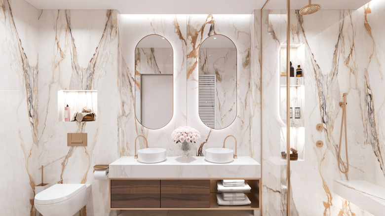 marble-looking tiles in a renovated bathroom with white and gold color scheme