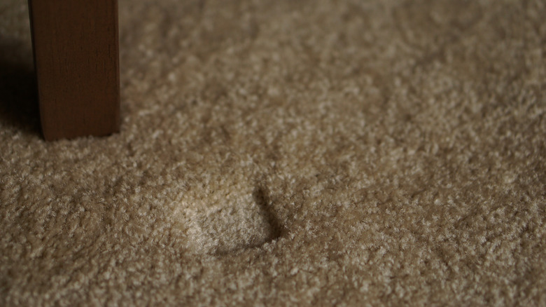 Dent in carpet pile from a chair leg
