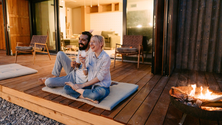 A couple enjoys an evening on their wood deck.