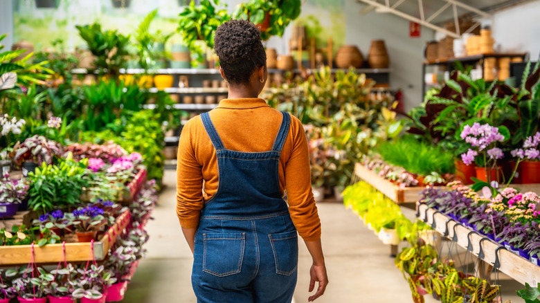 Woman walking through a garden center looking at plants