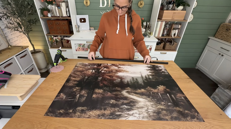 Woman holding broomstick and looking at poster