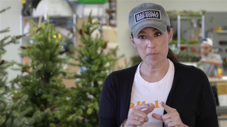Joanna Gaines in front of Christmas trees undecorated