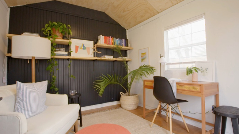 A living room with black painted beadboard