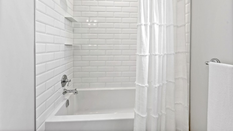 long white shower curtain with large textured pattern in small bathroom