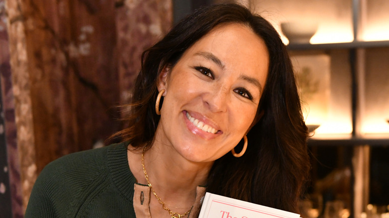 Joanna Gaines smiling while holding a book