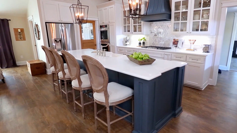 White kitchen with dark blue island and range hood