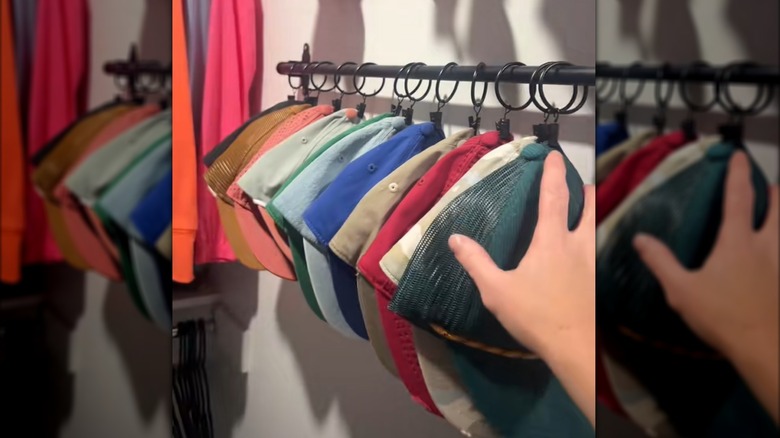 Woman showing off DIY curtain rod baseball hat holder on white wall