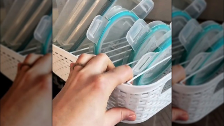 A Dollar Tree wire cabinet shelf inside of a plastic basket being used to organize Tupperware lids