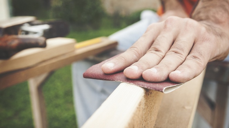 Person hand sanding edge of a door slab
