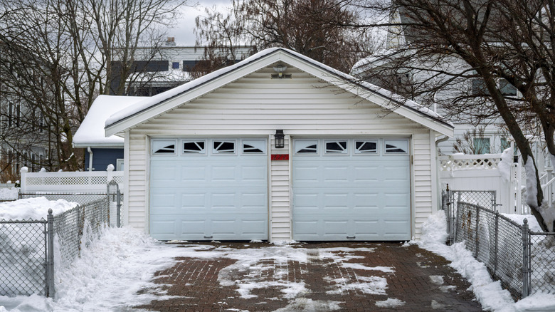 A detached garage surrounded by snow