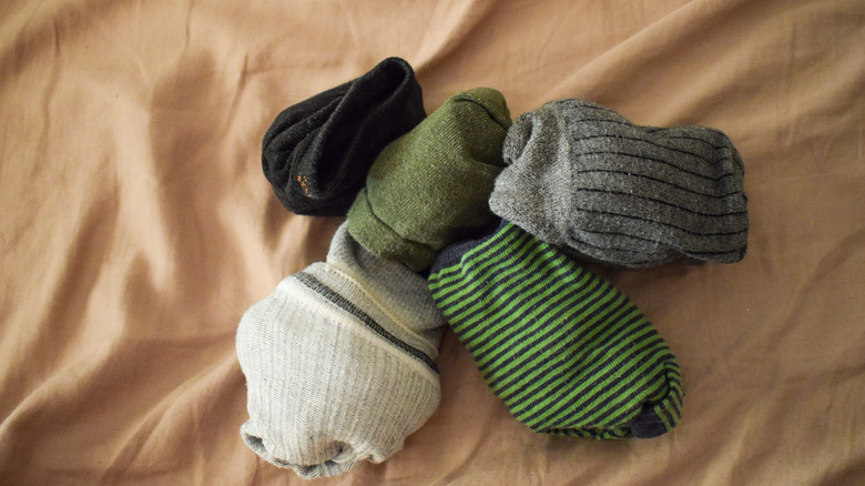 Rolled-up old, spare socks on bedsheet