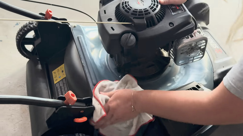 Person wiping wax onto lawn mower