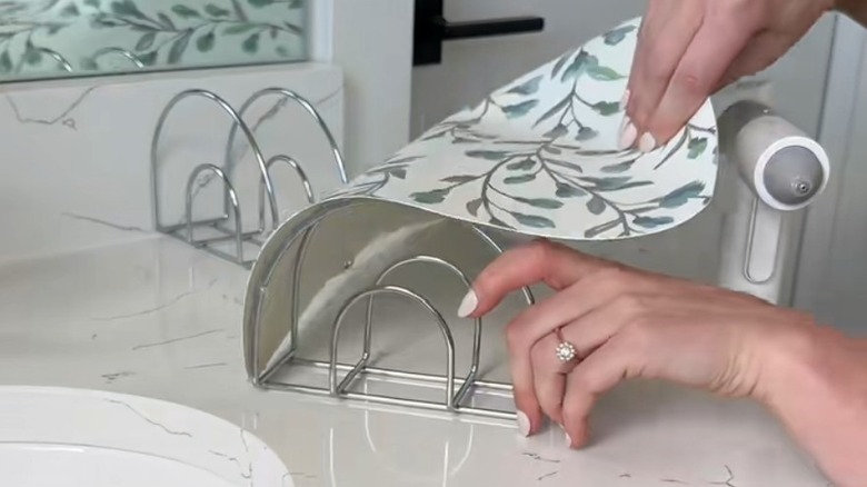 Hands wrapping Dollar Tree placemat around napkin holders
