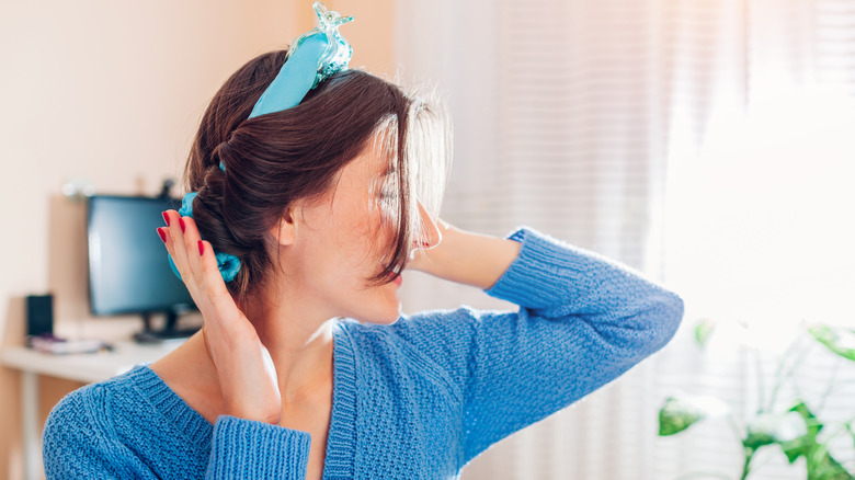 A woman puts on a blue hairband