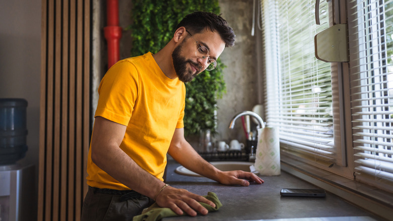 Man cleaning uncluttered counter