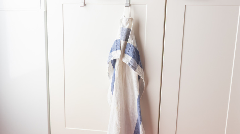A kitchen towel hanging up with a Command hook