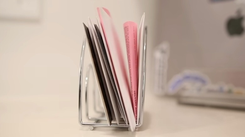 Envelopes stacked neatly in a metal napkin holder