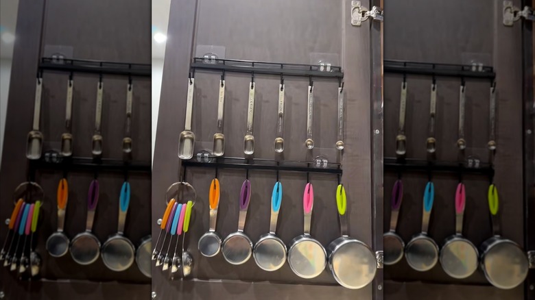 measuring cups hanging in cabinet