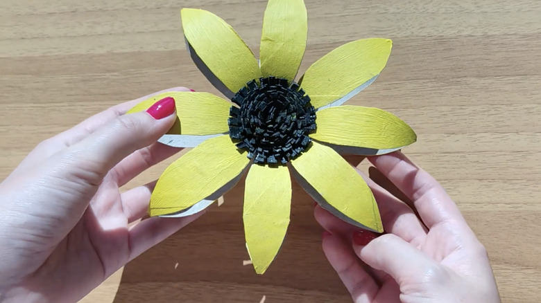 hands holding DIY cardboard sunflower