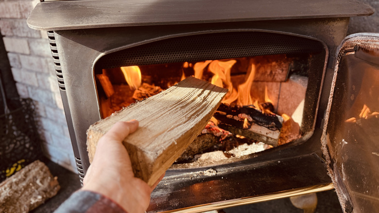 Loading wood into wood burning stove