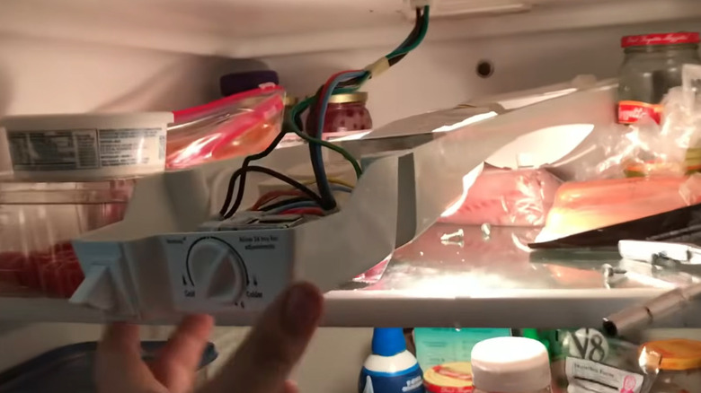 Hand showing location of frozen drain tube on Kenmore freezer-on-top refrigerator