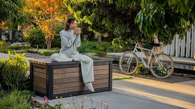 Woman sitting on a faux wood deck box.