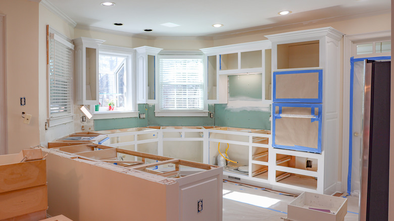 kitchen in the middle of a renovation with wood framing on cabinets and no countertops