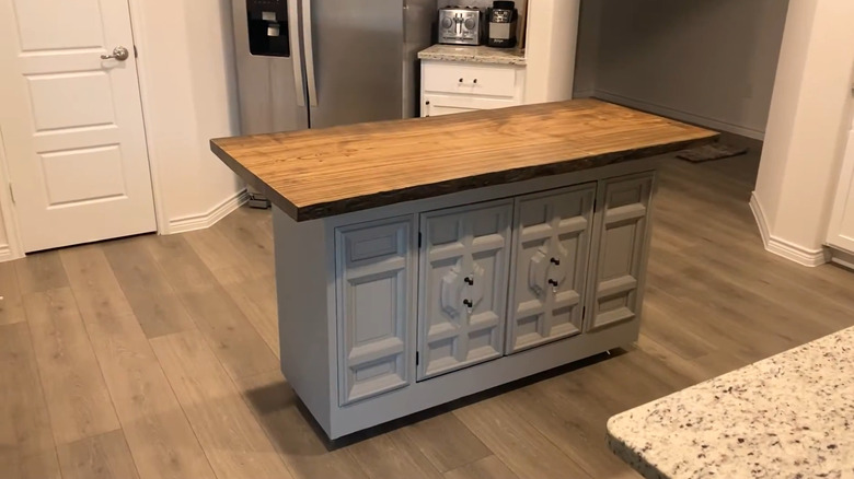 Sideboard that's painted and has a large top on it as a kitchen island