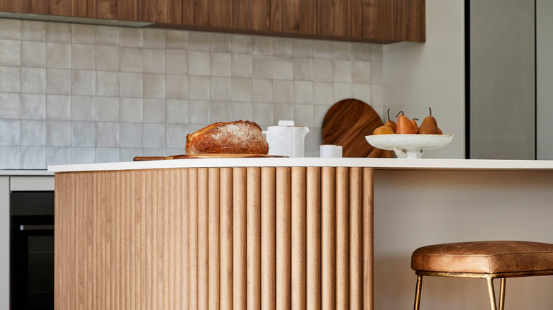Brown kitchen island with curved corners and fluted sides