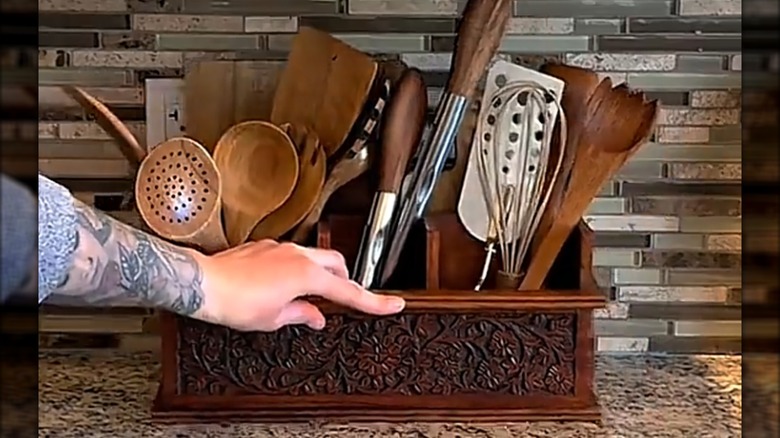 Person sliding a mail organizer used for kitchen storage against the wall on a countertop