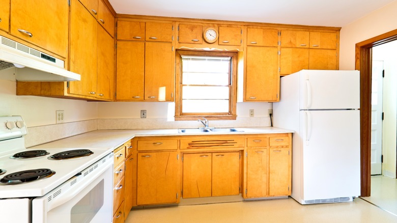 outdated empty kitchen with honey colored cabinets
