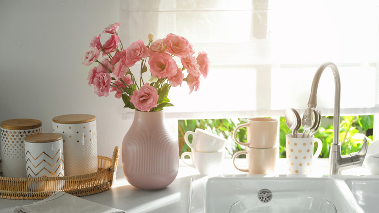 Roman shades on a window behind a kitchen sink