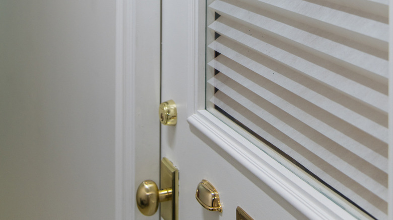 close up of door with glass panel and cellular shades for privacy