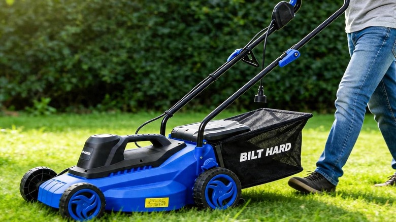 A person mowing a lawn with the BILT HARD 15" Corded Electric Lawn Mower