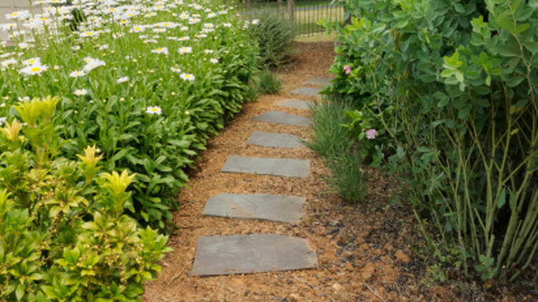 A garden pathway made from old slate roofing tiles adds a pretty touch to a flower garden.