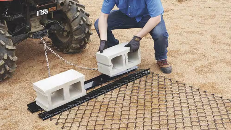 Loading weight onto a Yard Tuff 5-foot-by-4-foot ATV drag harrow
