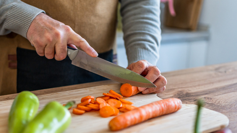 person cutting carrots with a knife