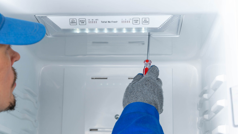 Repairman working on the inside of a freezer