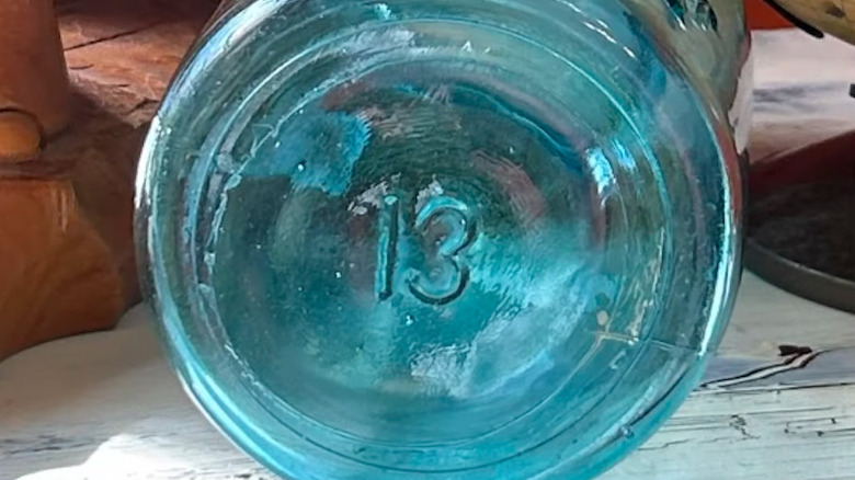 Bottom of antique Ball brand canning jar with blue glass and number 13