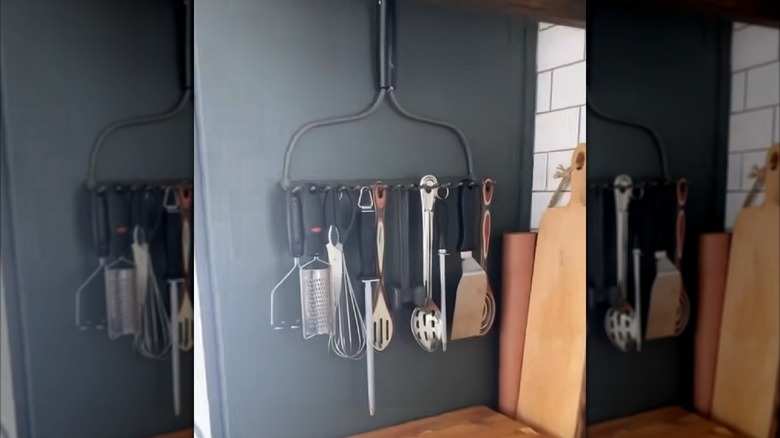 An old rake head turned into a kitchen storage rack for utensils